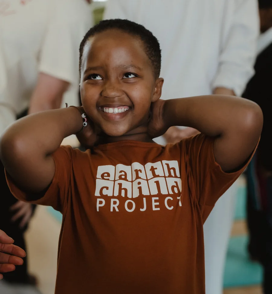 A smiling child in an Earthchild Project t-shirt in Khayelitsha, South Africa