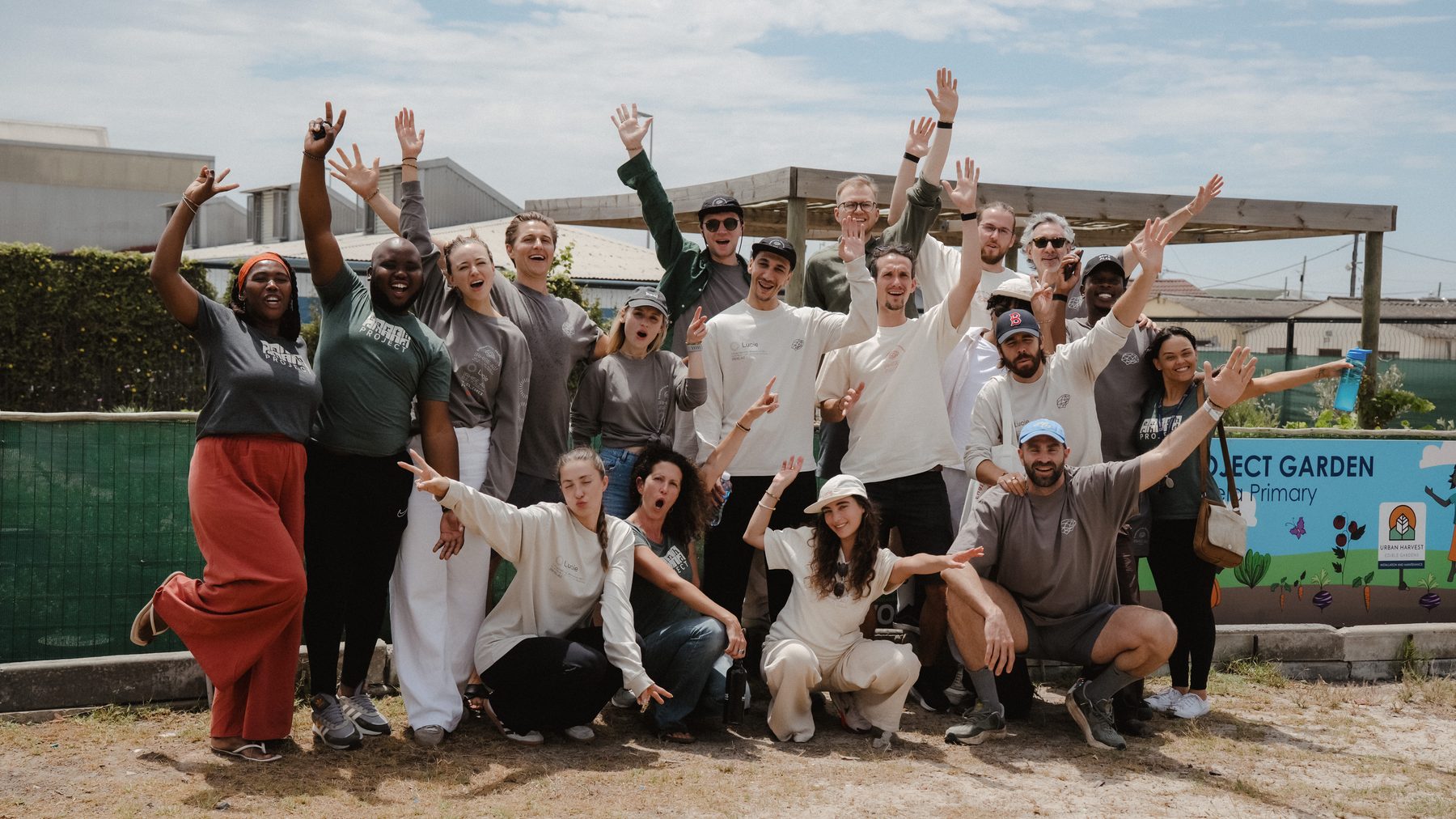The visiting group and Earthchild team cheering in front of the school garden.