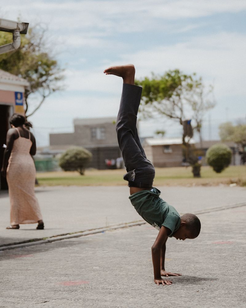 A child doing a handstand in the school yard.