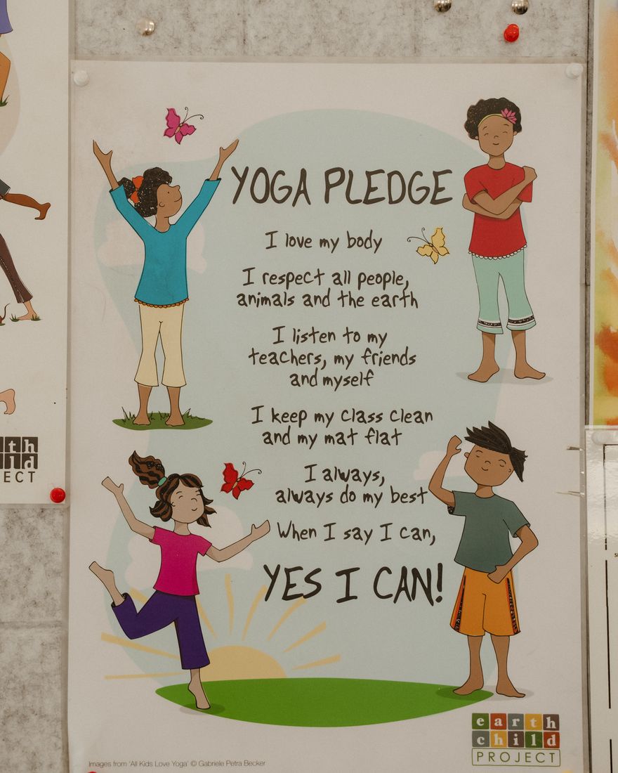 A hand painted yoga pledge poster on a classroom wall.